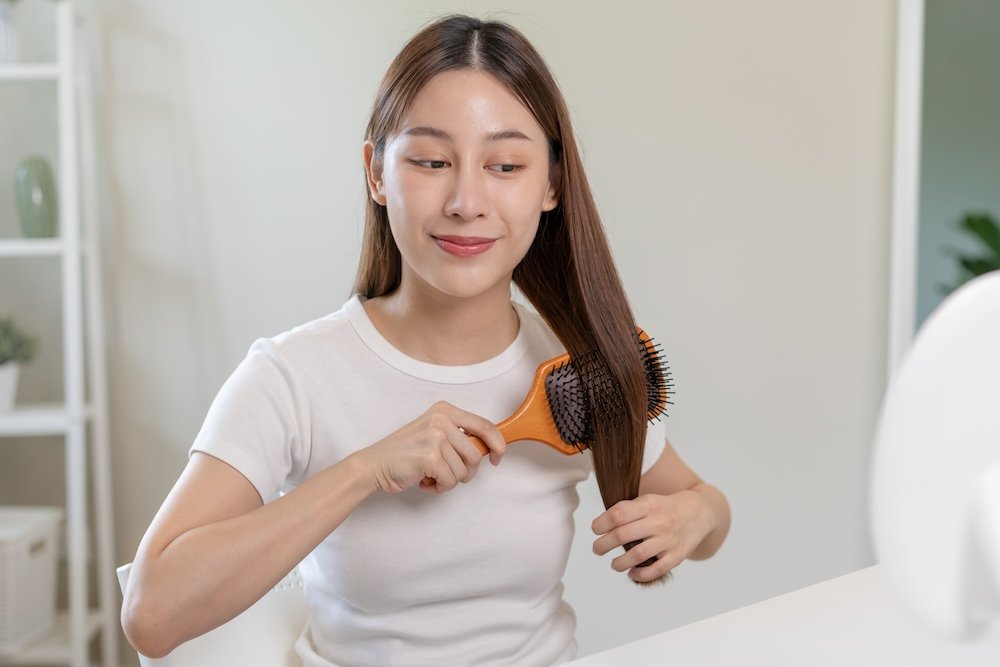 Does ginger help hair growth? A woman with shiny hair happily shows it does